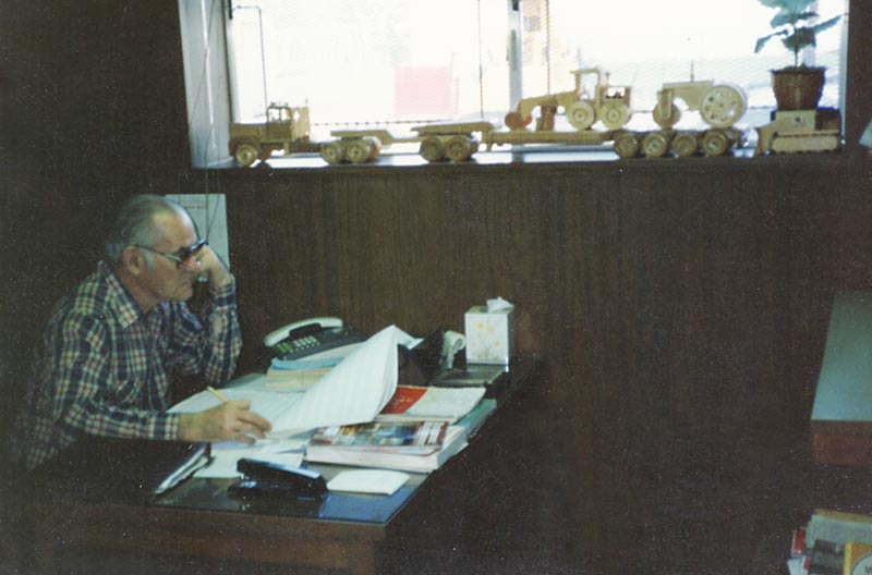 Perry Henderson at Work Perry sits in his old office, with several wooden models below the window.