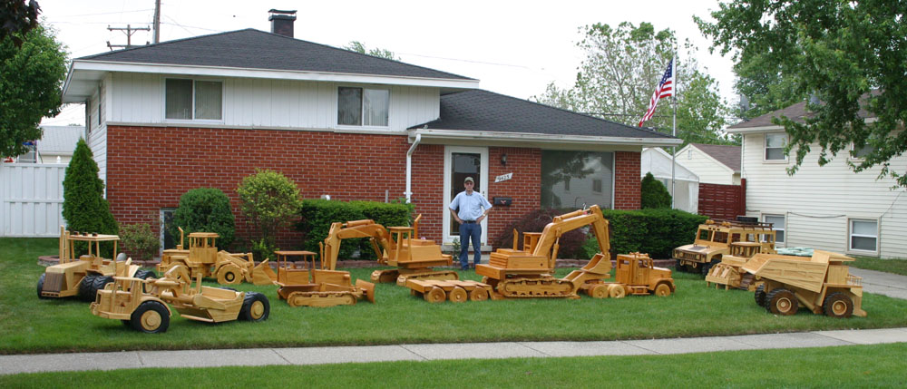 Chuck With His Models Chuck Hoggarth standing in front of his home with his collection of large scale construction equipment models.