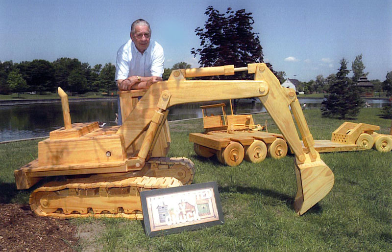 Chuck With His Models Chuck poses behind his scale model excavator.