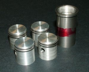 Final Pistons With Rings Ron’s finished pistons with rings, plus an extra sleeve and piston.