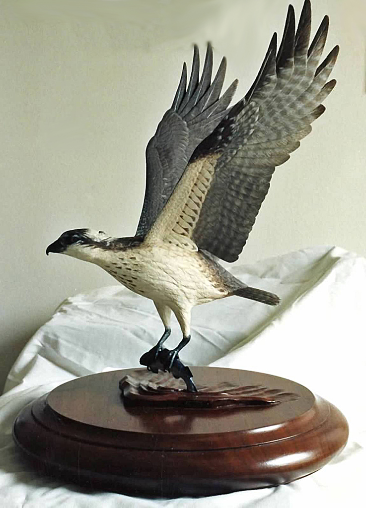 Osprey A carved wooden Osprey with fish in flight.