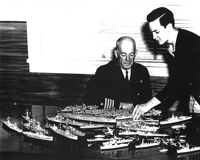 Bill Showing His Models Seventeen-year-old Bill Tompkins (right) points out some details on his models to Navy Captain H.C. Gearing.