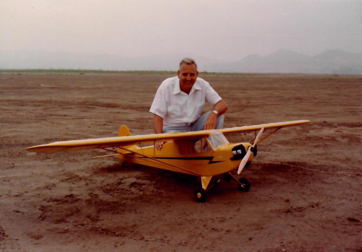 Dan Lutz With Piper Cub Mr. Lutz poses behind his scale model R/C Piper Cub airplane on the runway.