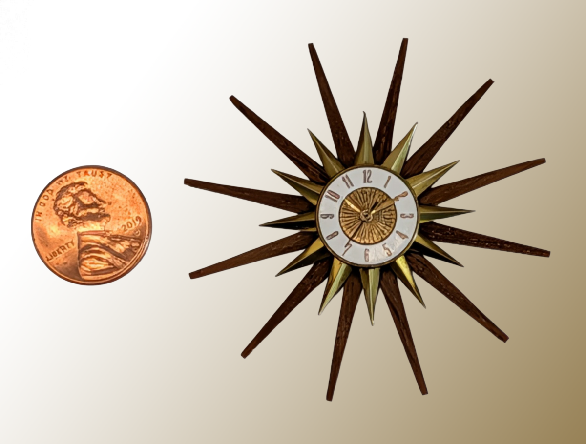 Elgin Starburst Clock A miniature Elgin Starburst Clock, copied from one that Mr. Elliott owns. Materials: Plastic frame, walnut veneer, brass spikes and face. 2.3x2.3x.3. Note: All dimensions are in inches WxHxT.
