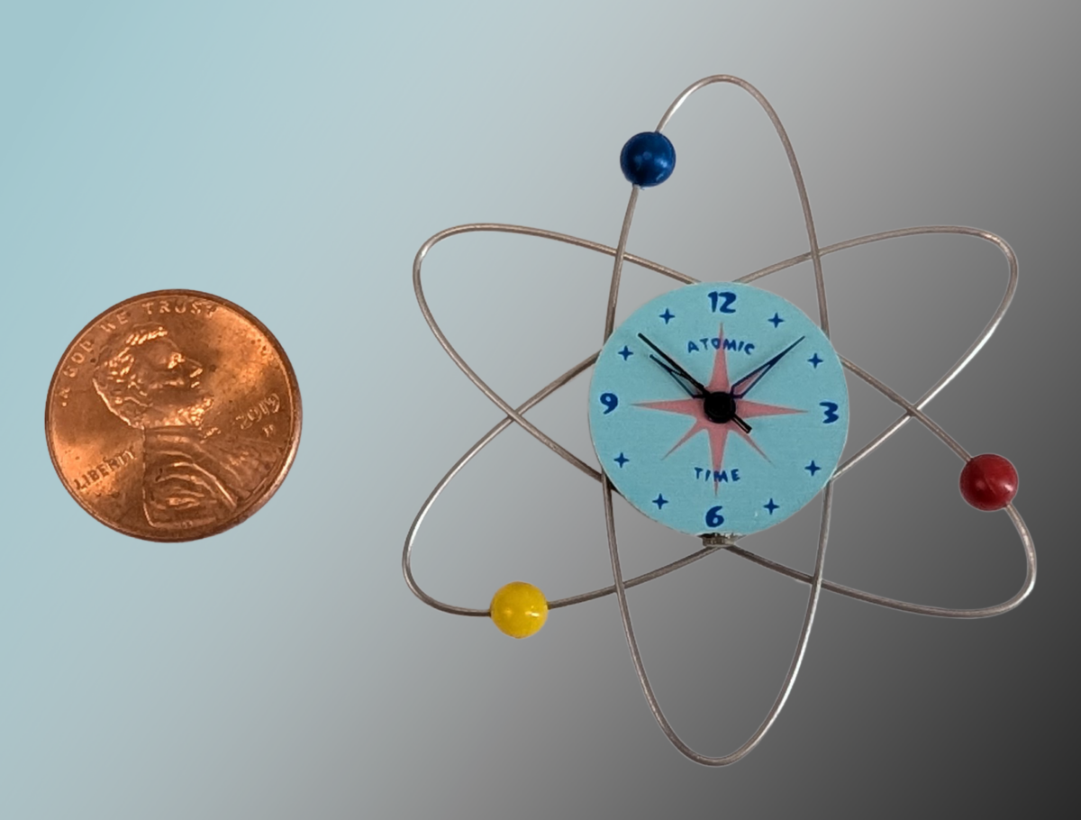 Atomic Wall Clock An Atomic Wall Clock from the 50s/60s. Materials: Plastic body (PLA), stainless steel rings, plastic “electrons”, brass dial plate. 2x2x.25